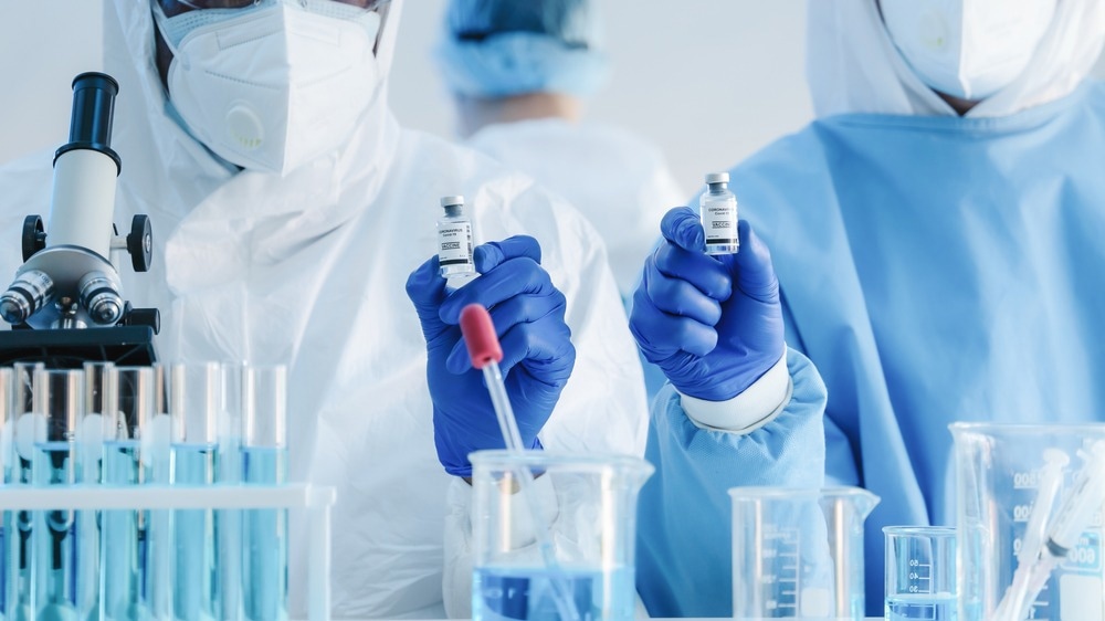 coronavirus covid-19 vaccine in hands of pharmacuetical bio research scientist in vaccine development laboratory, coronavirus covid-19 vaccine development program, selective focused