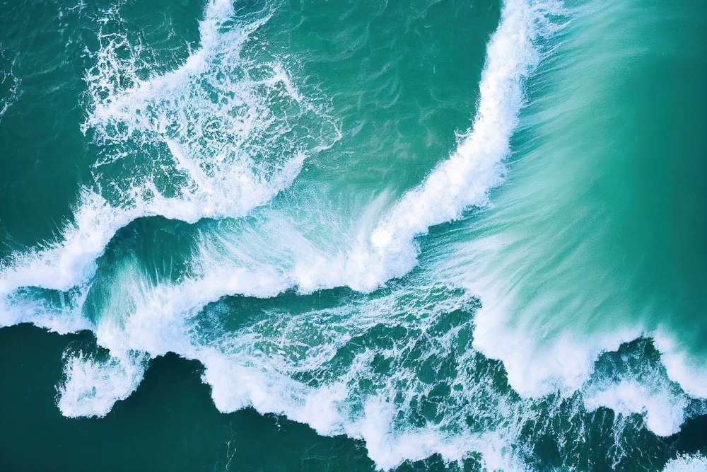 Spectacular aerial top view background photo of ocean sea water white wave splashing in the deep sea.