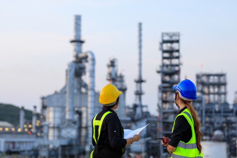 Smart two female engineer discussion together at refinery industry plant at industry factory center area. Engineering Concept