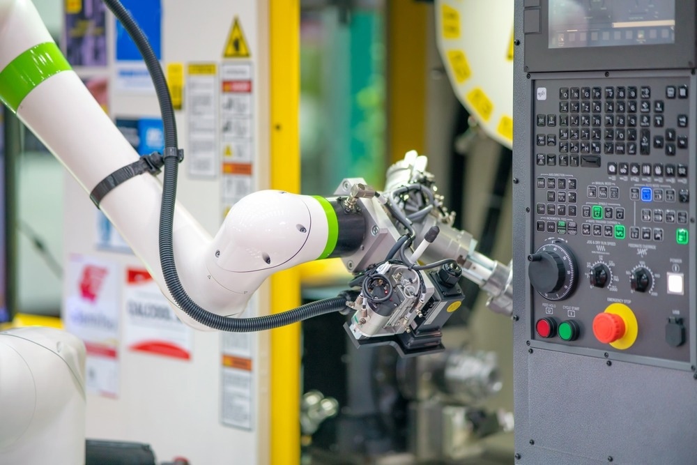 Factory 4.0 concept: The collaboration of robot and CNC machine, automotive part is taken into CNC milling machine automatically by gripper on cobot
