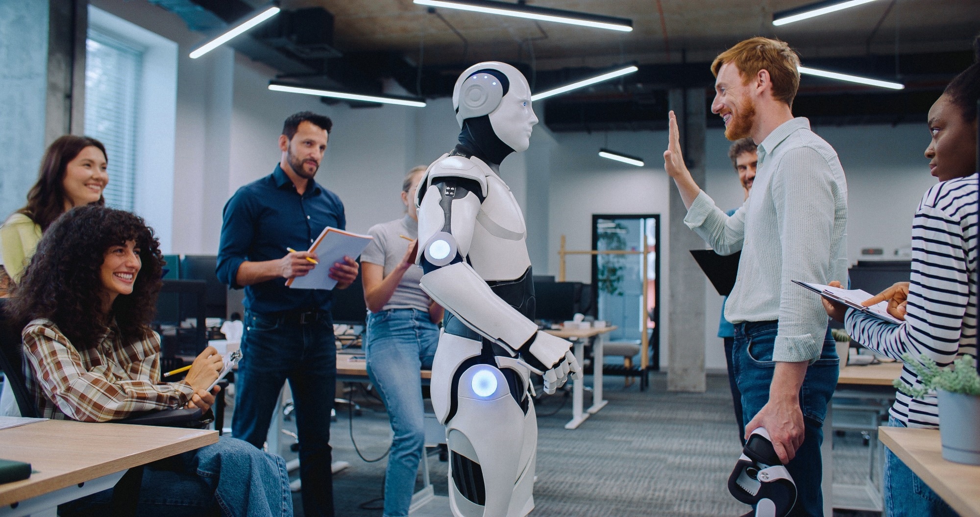 People gathering together to watch humanoid robot perform simple tasks.