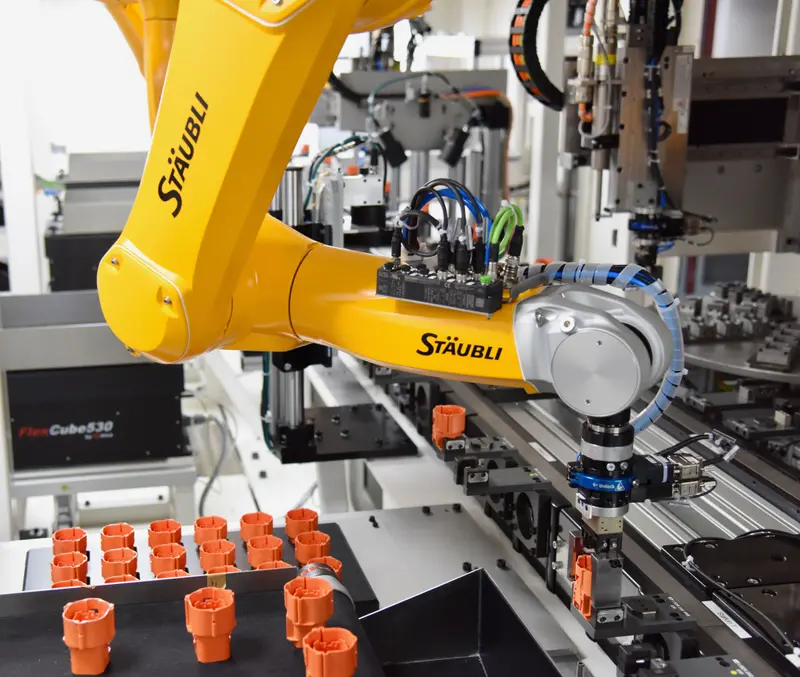 The first of the six installed TX2-60L robots places a connector housing into the workpiece carrier