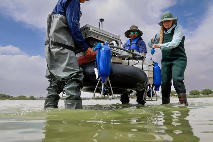 From left to right: UTEP alumnus Fernando Sotelo, doctoral student Jayanga Thanuka Samarasinghe and Assistant Professor Laura Alvarez, Ph.D., carry a boat from shore into Ascarate Lake, located in El Paso, Texas. The fully autonomous boat can carry out bathymetric surveys — surveys of the depth and terrain of bodies of water like oceans, rivers and lakes.