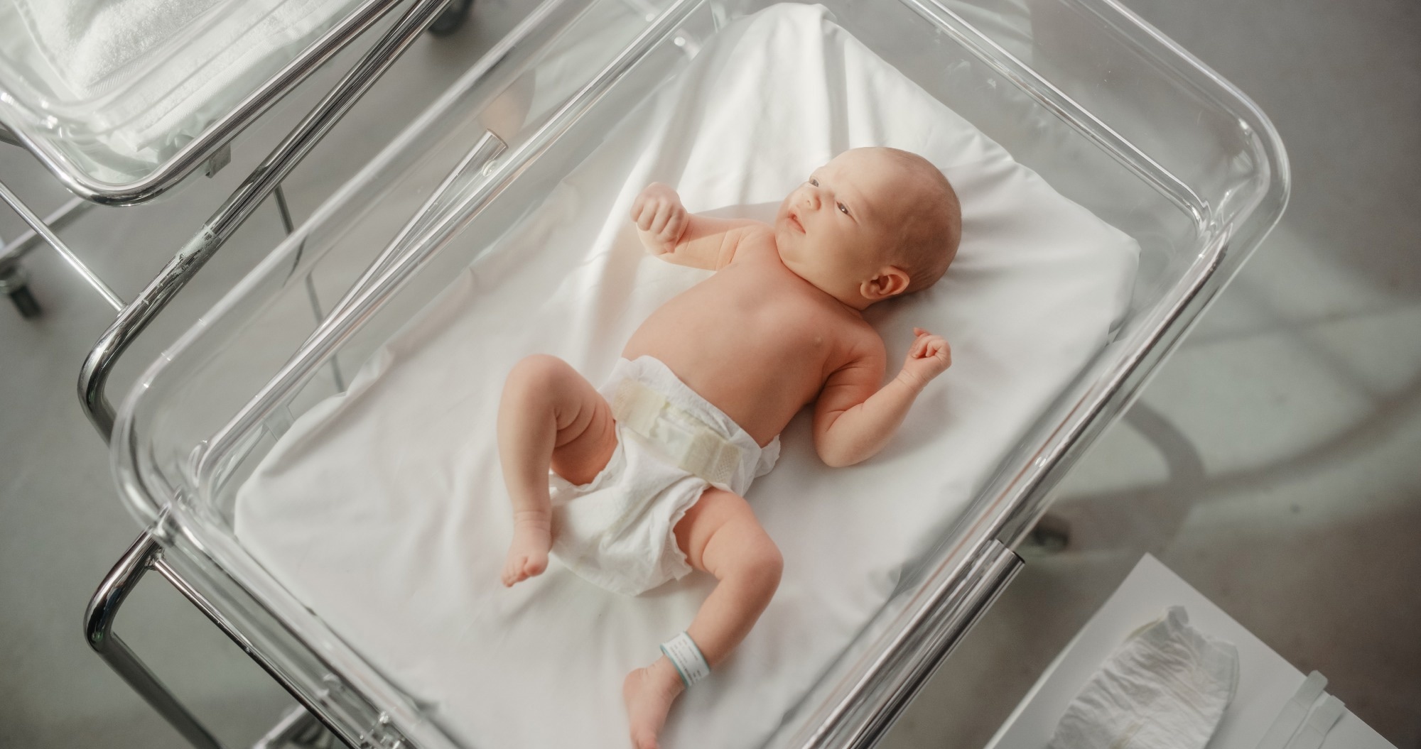 Newborn Child Lying in Hospital Bed in a Neonatal Clinic.