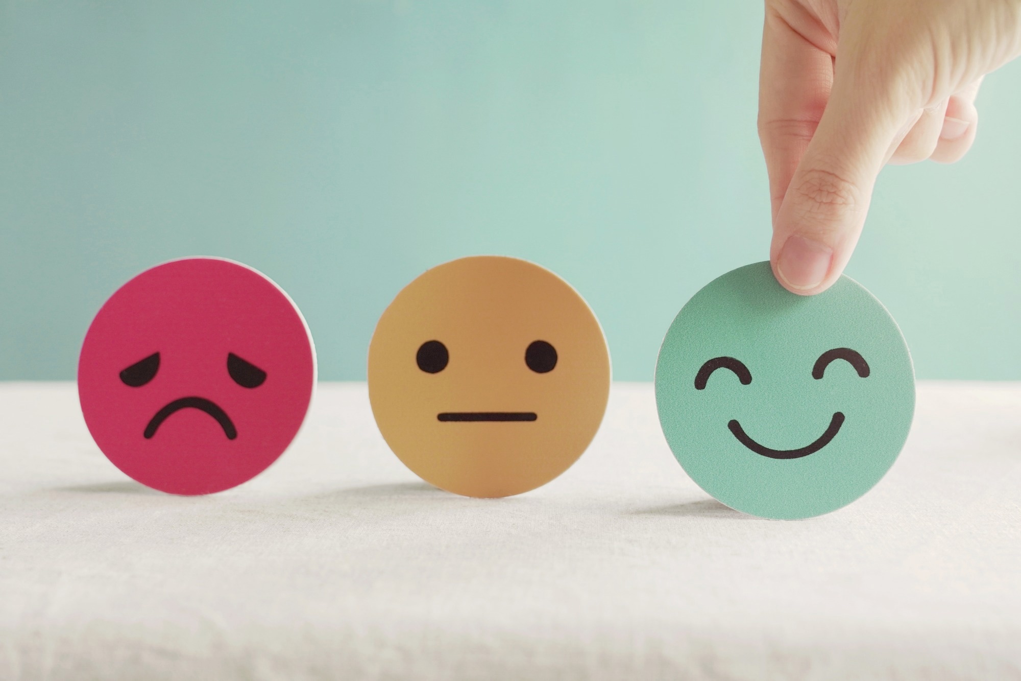 Mental health depicted in sad, neutral and happy faces.