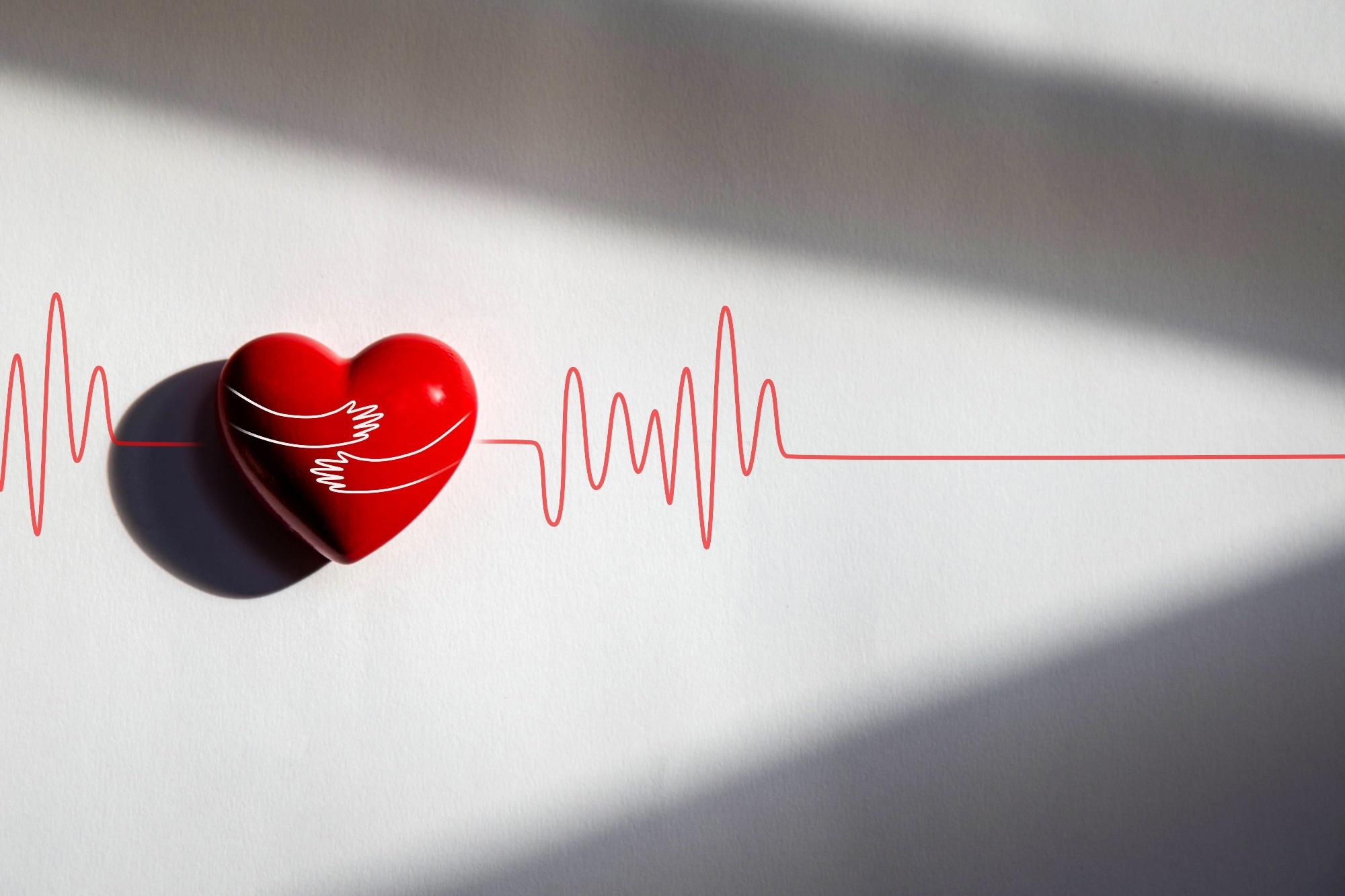 Red heart on white paper with a hug line drawing.
