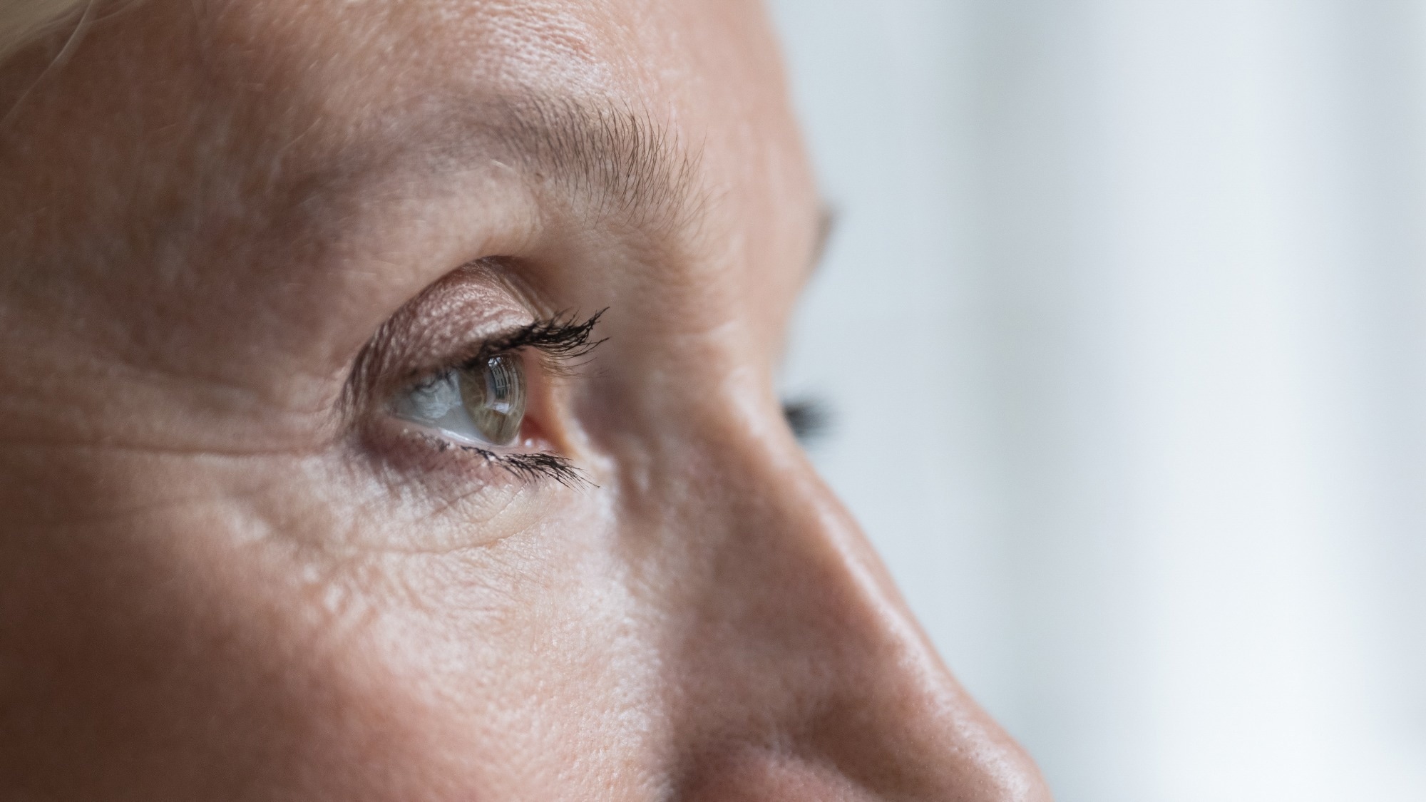 Close up cropped shot, face of senior woman eye looking straight, into distance.