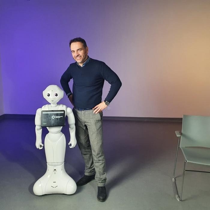 Photograph of Konrad Maj, Ph.D., from SWPS University, with a robot taking part in the study.