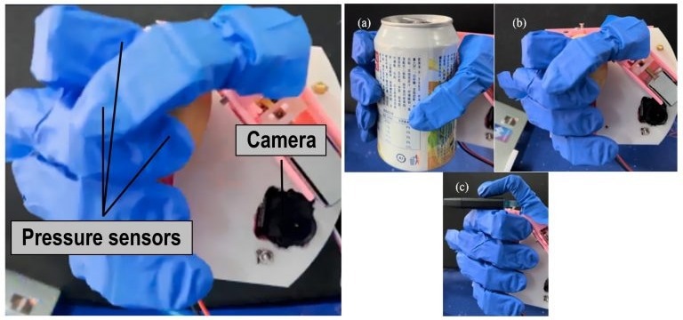 A robotic hand wearing a blue vinyl glove squeezes a range of objects, including a camera and a drinks can.