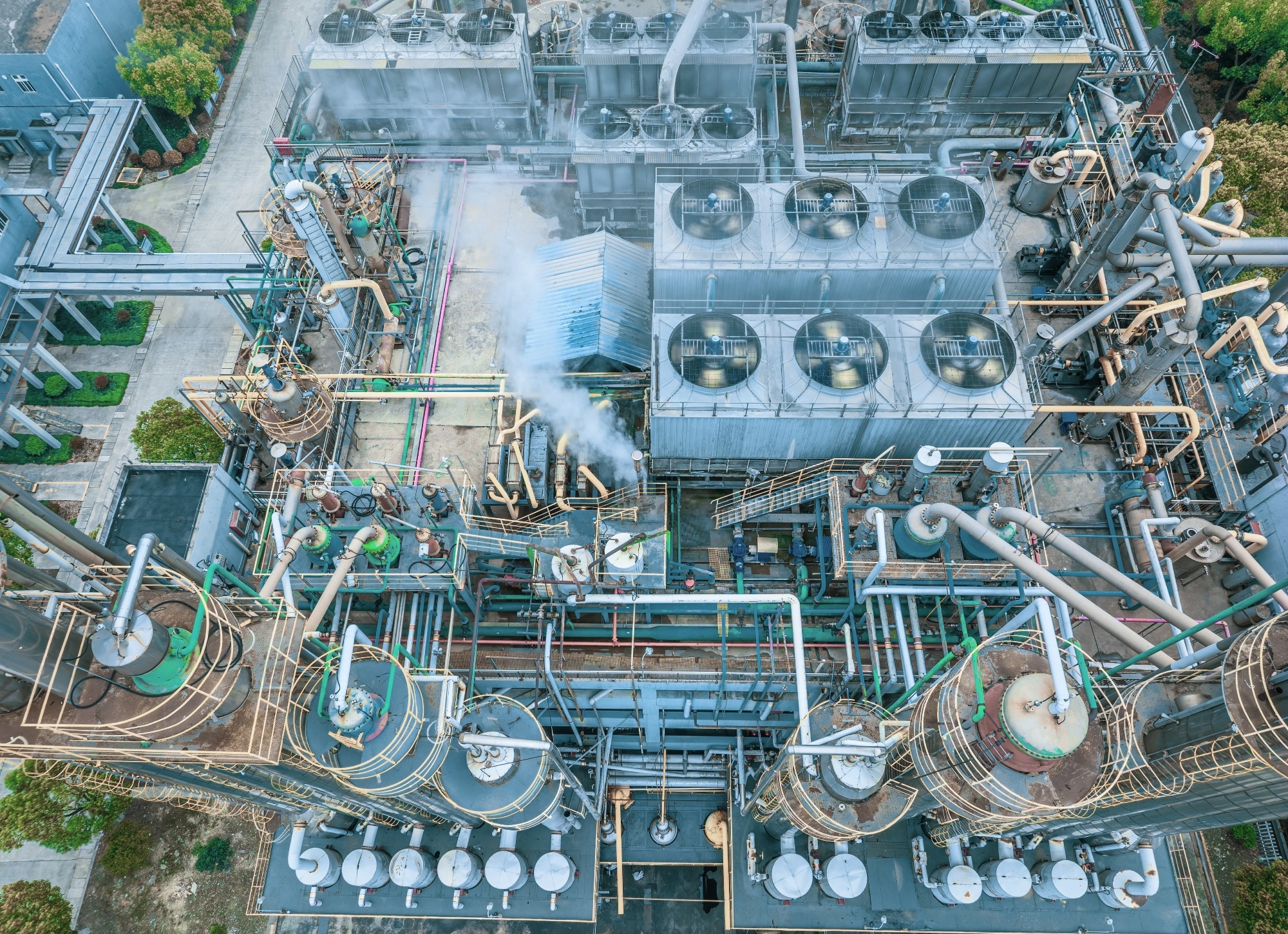 Complex chemical processing facility showing intricate network of pipes and industrial equipment.